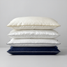 Stack of four silk pillows in ivory-silver, ivory-gold, ivory-navy and navy-white pillowcases